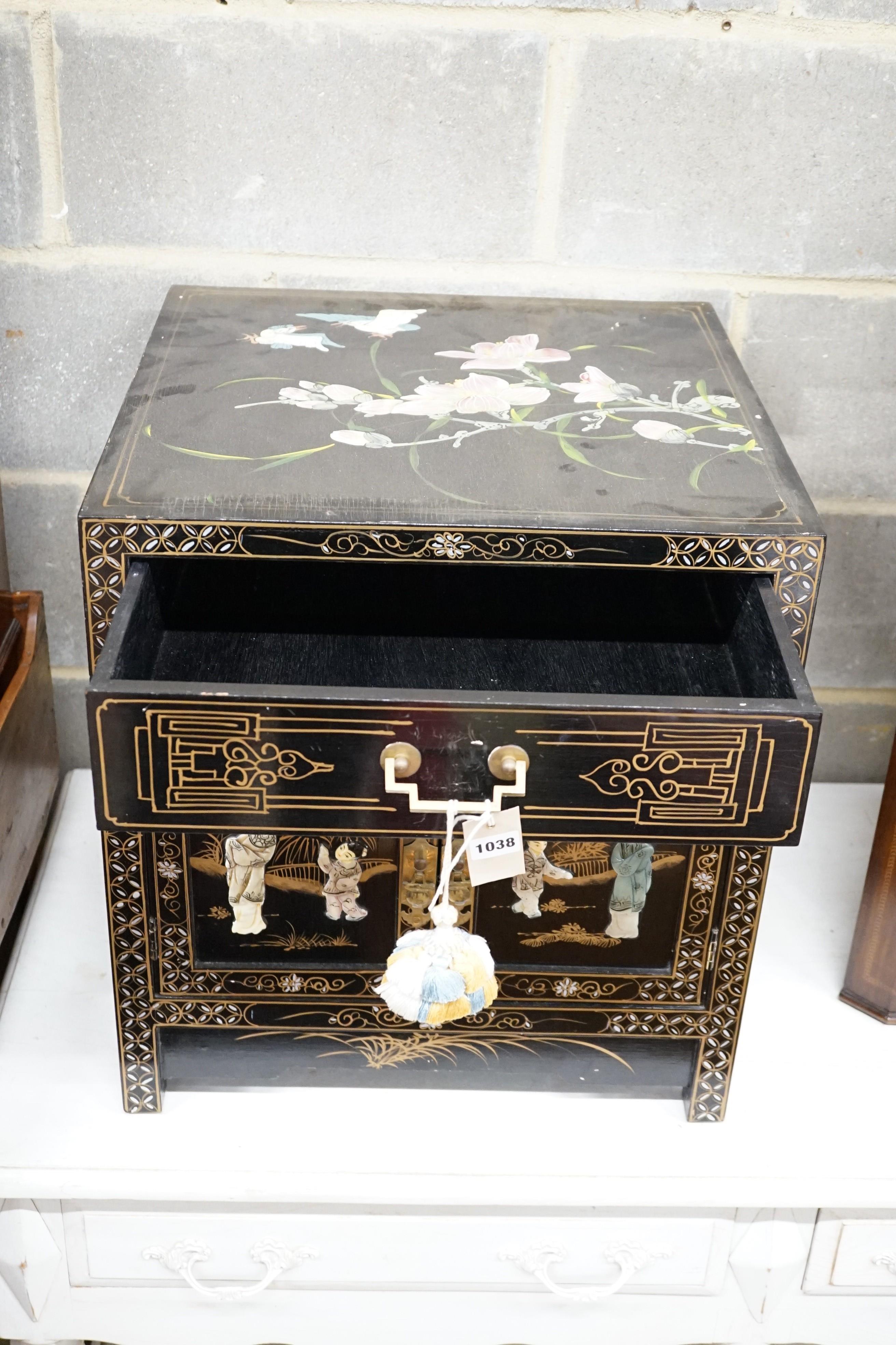 A Chinese black-lacquered brass-mounted small two-door cabinet, the door panels decorated with figures, width 51cm, depth 51cm, height 56cm.
